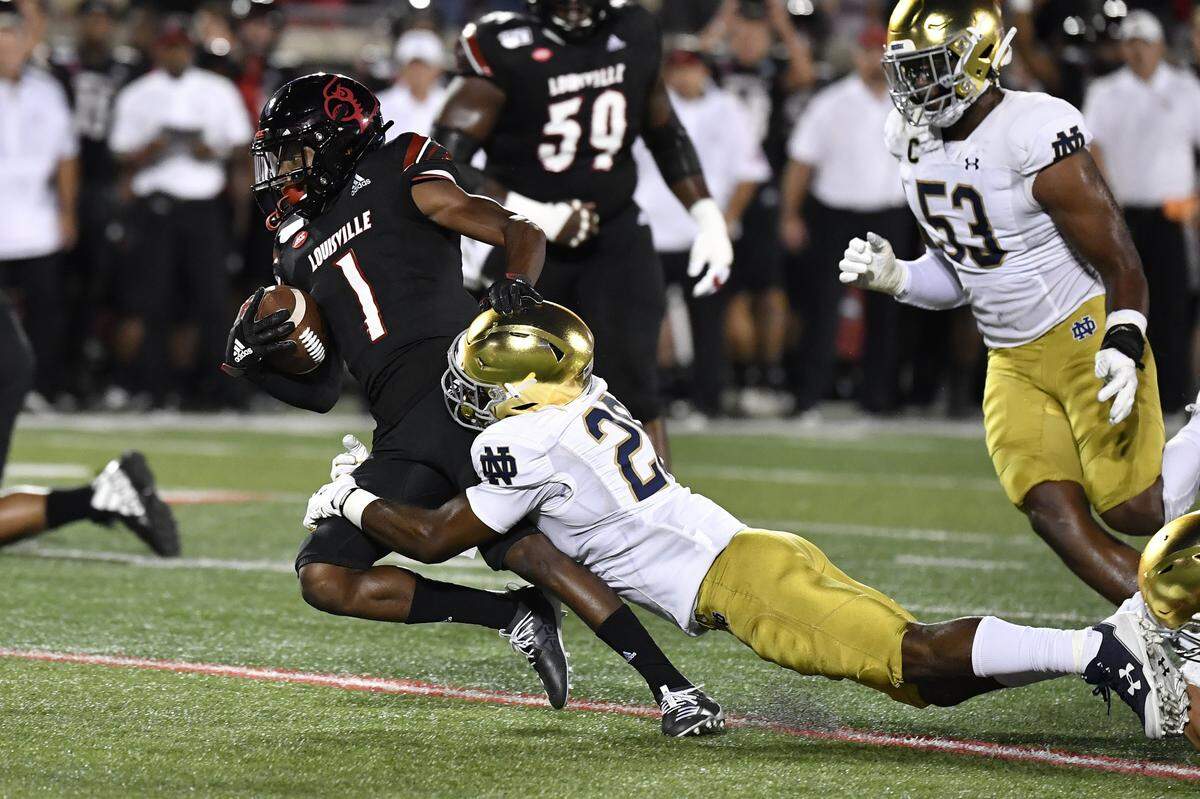 Notre Dame cornerback Shaun Crawford (20) grabbed Louisville wide receiver Tutu Atwell (1) during the first half Monday night. Atwell led U of L with five catches for 47 yards.