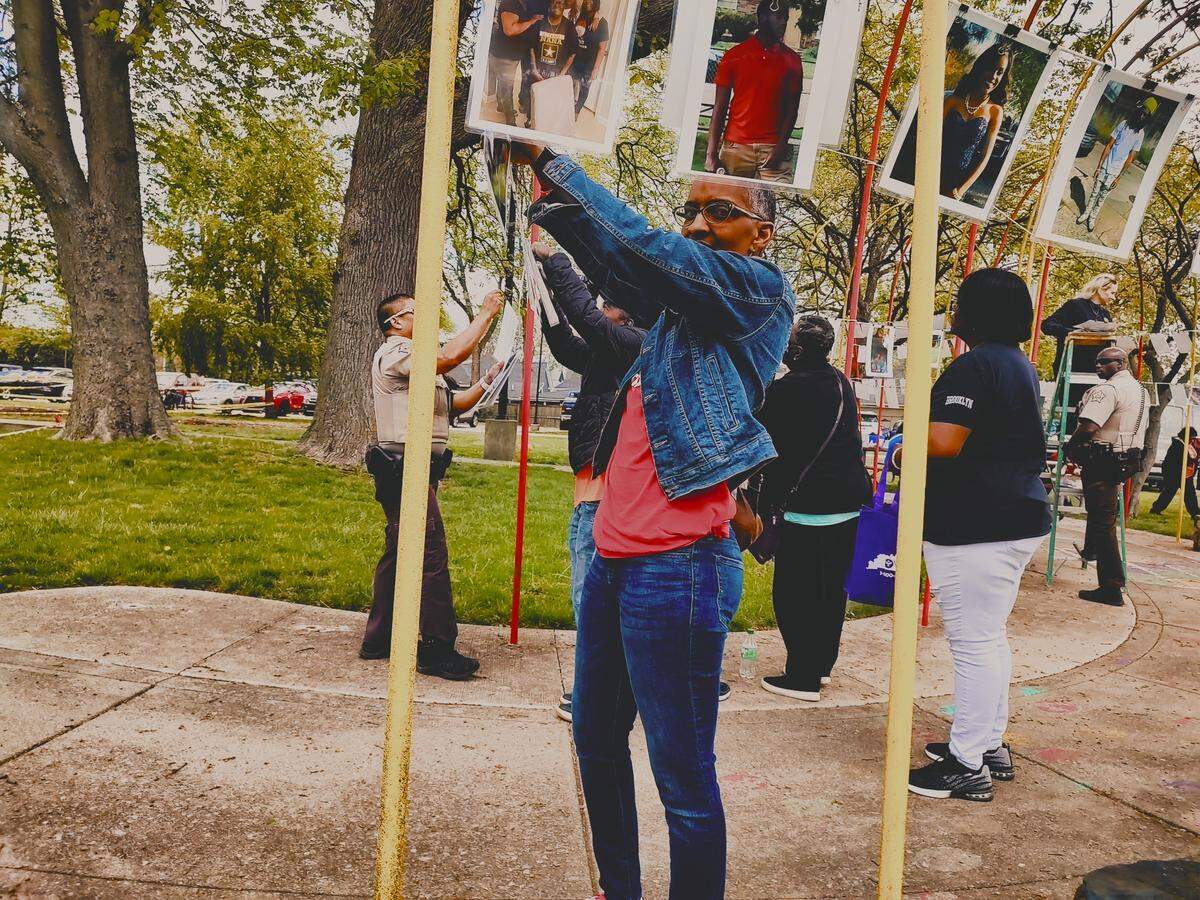 Cathy Swain hung photos of victims of gun violence at the Antonio Franklin Jr. Violence Intervention Project Peace Walk Saturday, April 22, 2023, at Duncan Park.