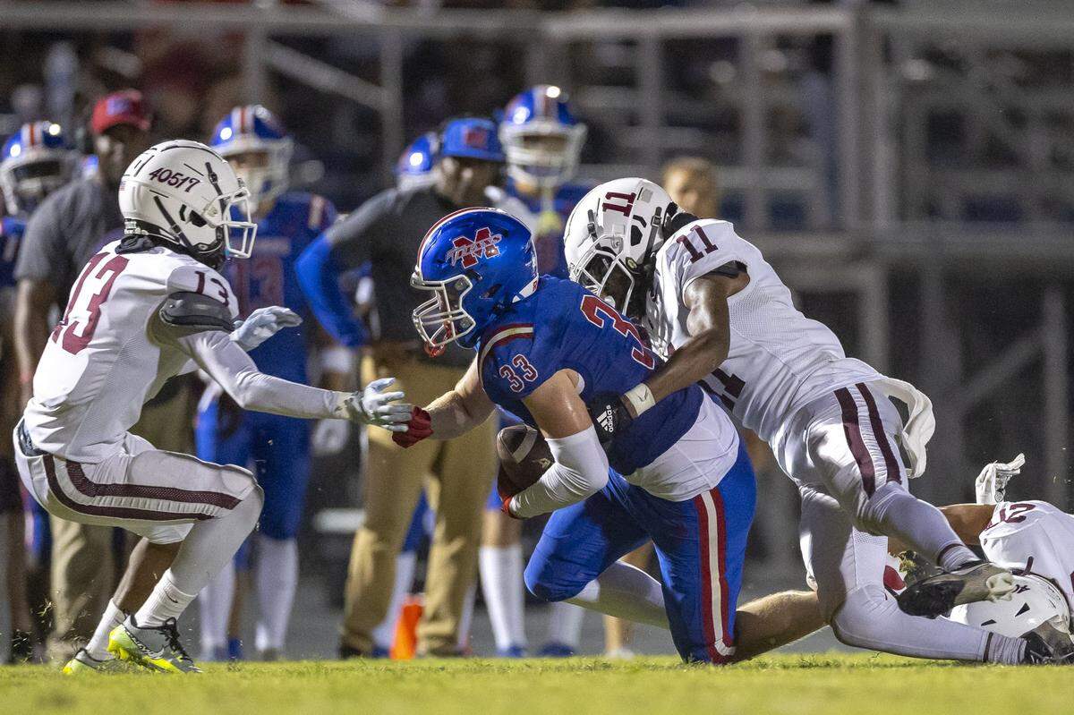 Mercer County's Jacob Sanford (33) is tackled by Tates Creek's Shawn Taylor (11) during the Fort Harrod Bowl at Alvis Johnson Field in Harrodsburg, Ky., on Saturday, Aug. 23, 2025.