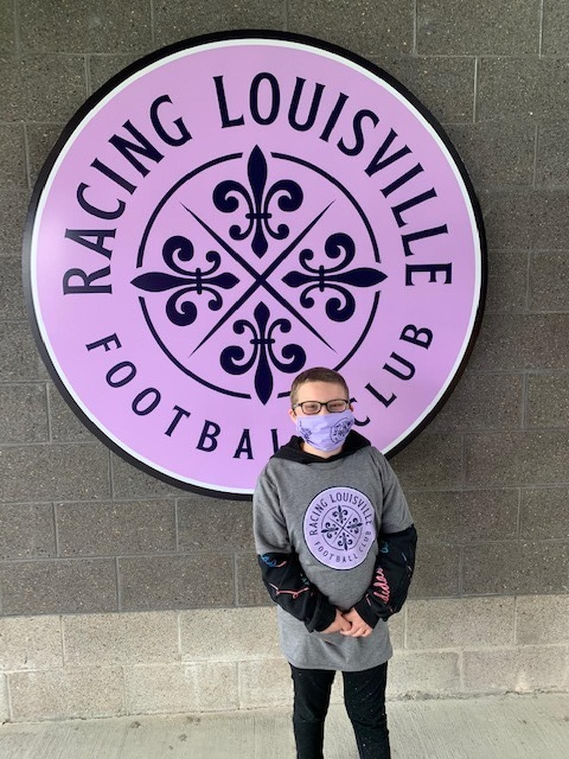 Ellie Hurley, 9, stands in front of a Louisville Racing Football Club sign. Hurley, a two-time leukemia survivor, recently finished her chemotherapy treatments, and the soccer team took her out for ice cream to celebrate. Photo courtesy of Morgan Hurley.