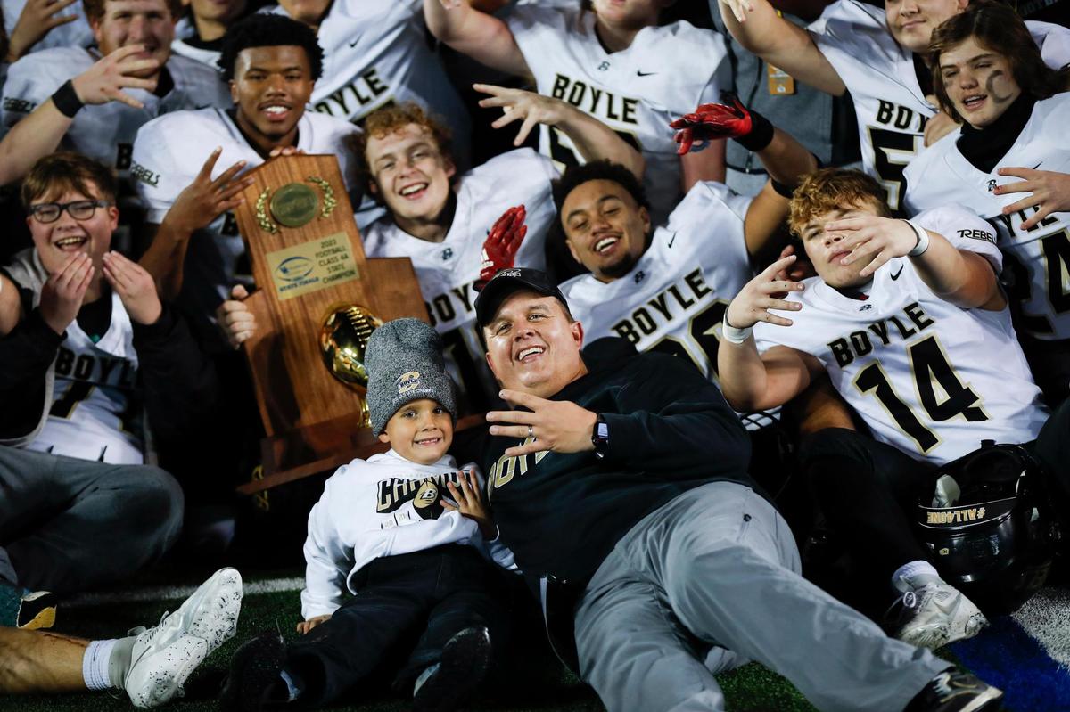 Boyle County head coach Justin Haddix, center, celebrates with his team and son after the Rebels defeated Covington Catholic for the program’s fourth straight KHSAA Class 4A football state championship at Kroger Field on Friday.