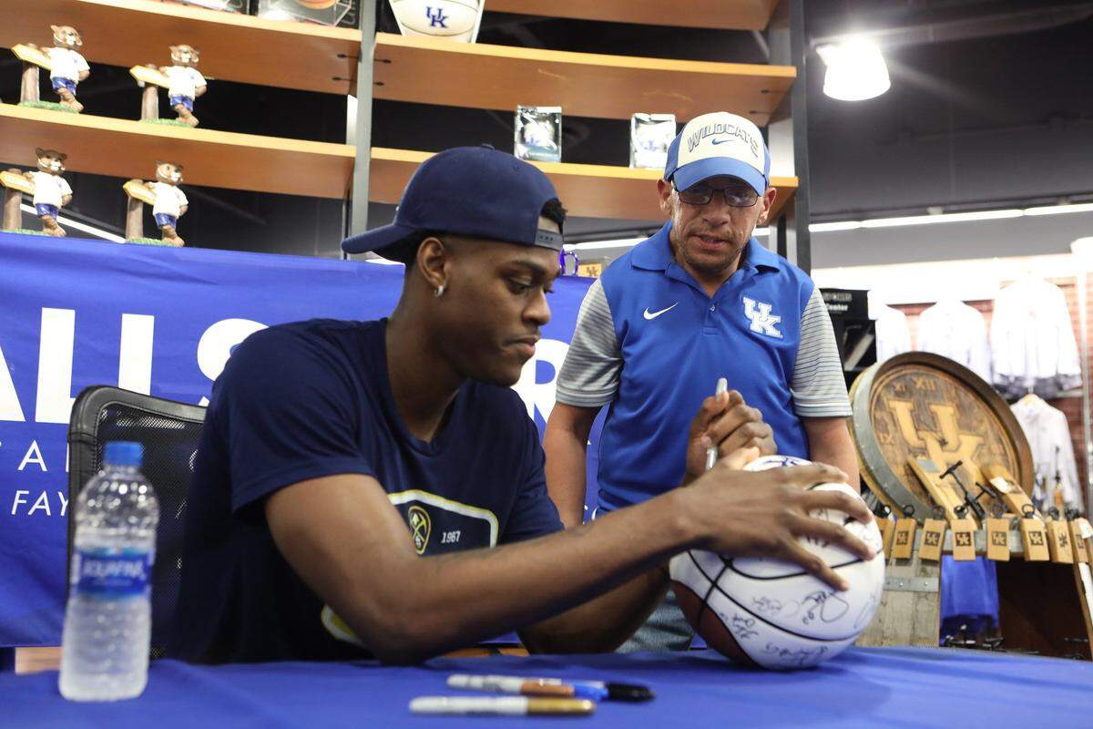 Ronnie Justice of Pikeville watched as former UK player Jarred Vanderbilt signed his UK basketball on Tuesday evening during an autograph session at Allsports in Fayette Mall.