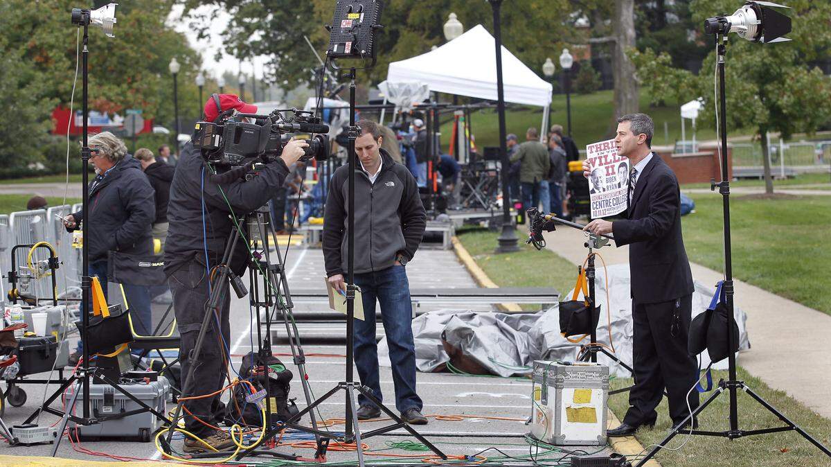 CNN reporter Paul Steinhauser, right, did a live report from the front of The Norton Center for the Arts on the Centre College campus in Danville, Ky., Wednesday, October 10, 2012. The vice presidential debate between Democratic incumbent Vice President Joe Biden and Republican challenger Paul Ryan will be held Thursday night in the Norton Center for the Arts on the Centre campus. On the far left is photojournalist Mark Walz. Steve Sorg was operating the camera and producer Justin Lear was in the middle. Photo by Charles Bertram | Staff