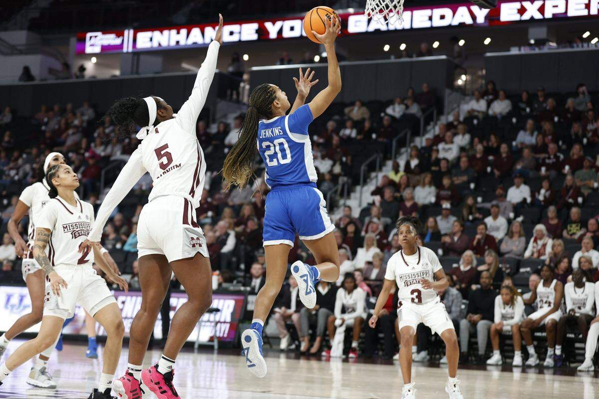 Kentucky’s Amiya Jenkins (20) drives to the basket past Mississippi State’s Erynn Barnum in Starkville on Thursday night. The Wildcats closed the game with a 19-0 flurry to overcome a 10-point fourth quarter deficit.