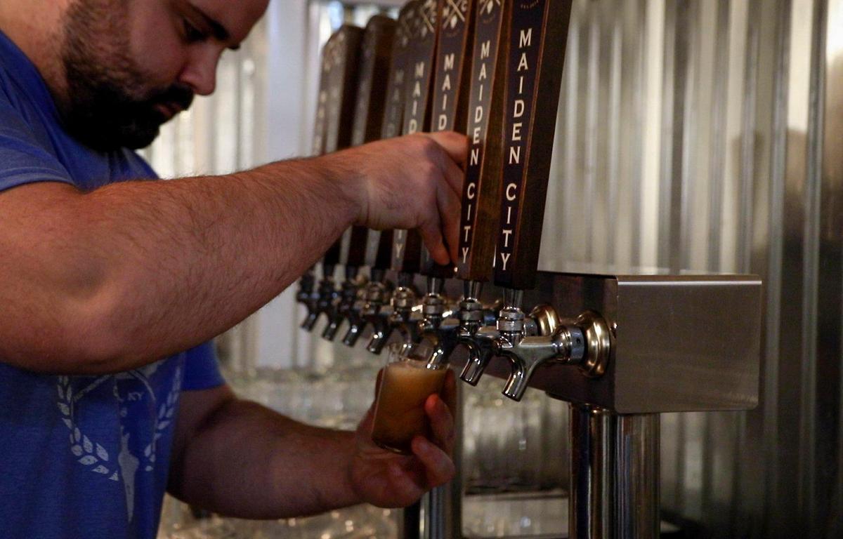 Co-owner, Austin Dacci, pours for a flight of beers at Maiden City Brewing’s downtown location in Cynthiana., Thursday, Jan. 7. Maiden City has announced that they are expanding from one downtown location to a new venue and taproom in Cynthiana as well as adding a location in Paris. The new main location will be at the Harrison County business park and hopes to offer a large outdoor patio and dedicated event space.