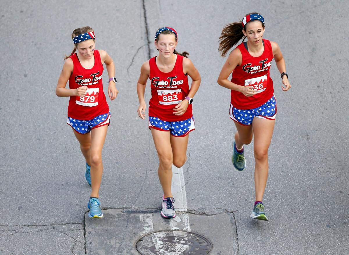 Left to right: Sydney Liddle, Ashlyn Liddle and McKenna Cavanaugh ran down East Vine Street during the 42nd annual Fourth of July Bluegrass 10,000 road race through downtown Lexington. The overall winner was Zack Beavin and the top female finisher was Katy Kunc.