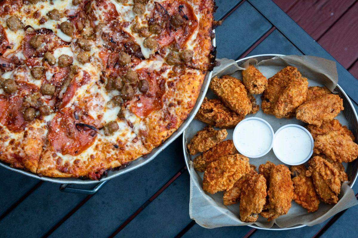 A meat lover’s pizza and Buff Stuff wings from Madison Garden Bar and Grill in Richmond. Wings with Buff Stuff seasoning is one of the restaurant’s best selling items.