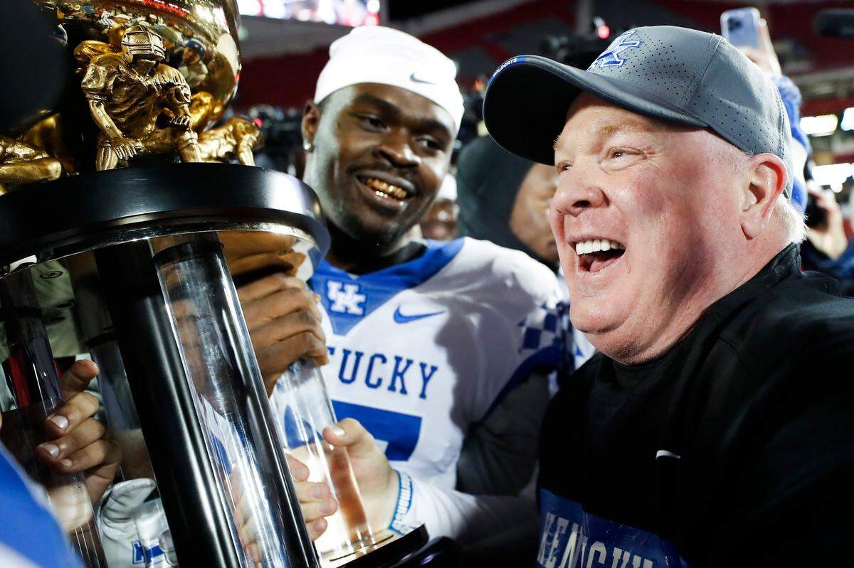 Kentucky head coach Mark Stoops celebrates with the team and the Governor’s Cup after beating Louisville last November. Stoops agreed to a contract extension late last season.