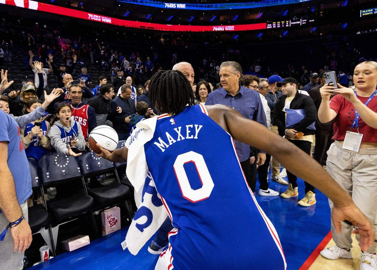 With Kentucky Coach John Calipari watching nearby, 76ers guard Tyrese Maxey gives his game ball to a young fan after his team's victory against the Nets in Game 2 of their playoff series on Monday night.