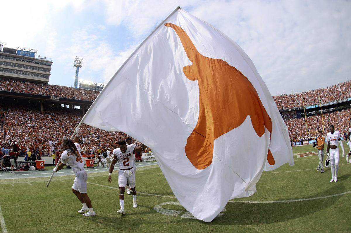 Oct 8, 2022; Dallas, Texas, USA;  Texas Longhorns wide receiver Jordan Whittington (4) and Texas Longhorns running back Roschon Johnson (2) wave a Texas flag after the game against the Oklahoma Sooners at the Cotton Bowl. Mandatory Credit: Kevin Jairaj-USA TODAY Sports