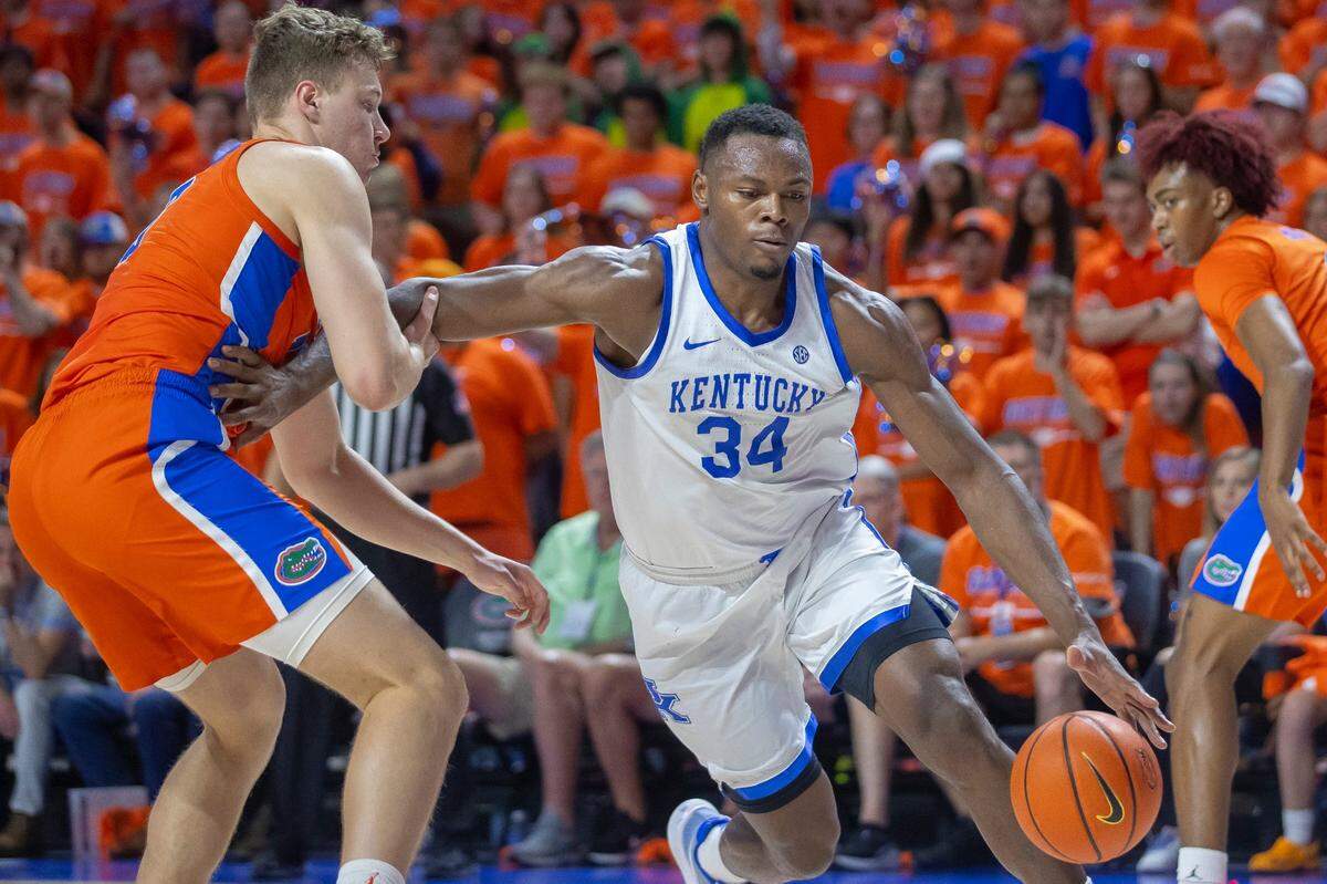 Kentucky forward Oscar Tshiebwe (34) drives the ball past Florida forward Aleks Szymczyk (13) during Wednesday’s game at the Stephen C. O’Connell Center in Gainesville, Fla.