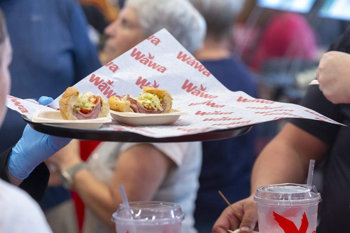Wawa employees hand out samples of food and drinks, including an Italian hoagie, during an event for VIP customers at the company's first Central Kentucky location at 3000 Lexington Road in Nicholasville, Ky., on Wednesday, Sept. 10, 2025. The location is scheduled to open Friday.