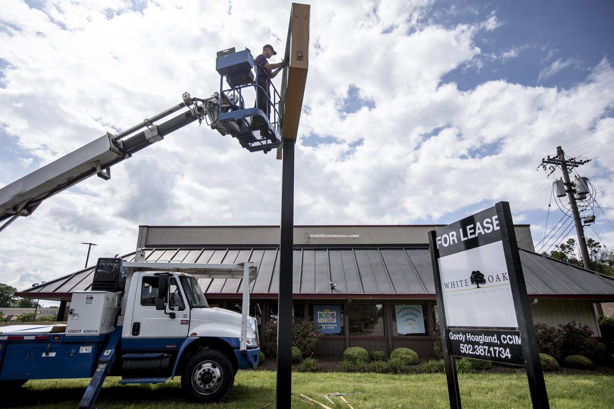 Jonathan Meeksoul, of Image 360, takes down the Denny’s sign May 22 at the restaurant’s former Lexington location at 1949 Nicholasville Rd.