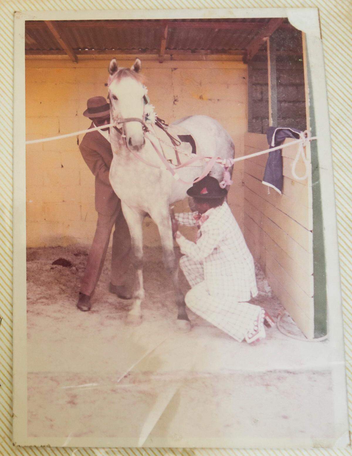 A younger Larry Demeritte with his father Thomas -- who is standing -- from the early 1970s. The two were preparing a horse for a race. Tragically, Thomas would be killed in the 1980s while breaking a horse.