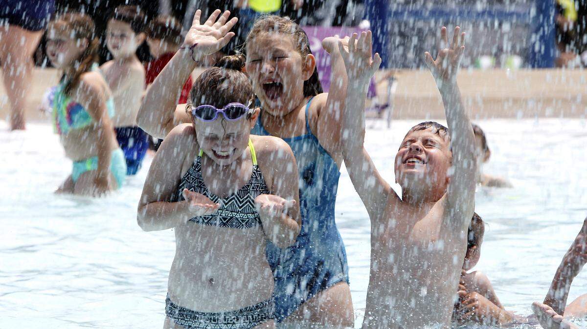 Grace Gossett, left, Rilke Bell-Frantz and Collier Quick reacted as water was dumped on them during Poolapalooza at Southland Aquatic Center. Lexington will offer half-price admission to all city pools and aquatics centers on Wednesday as temperatures are expected to climb into the mid-nineties.