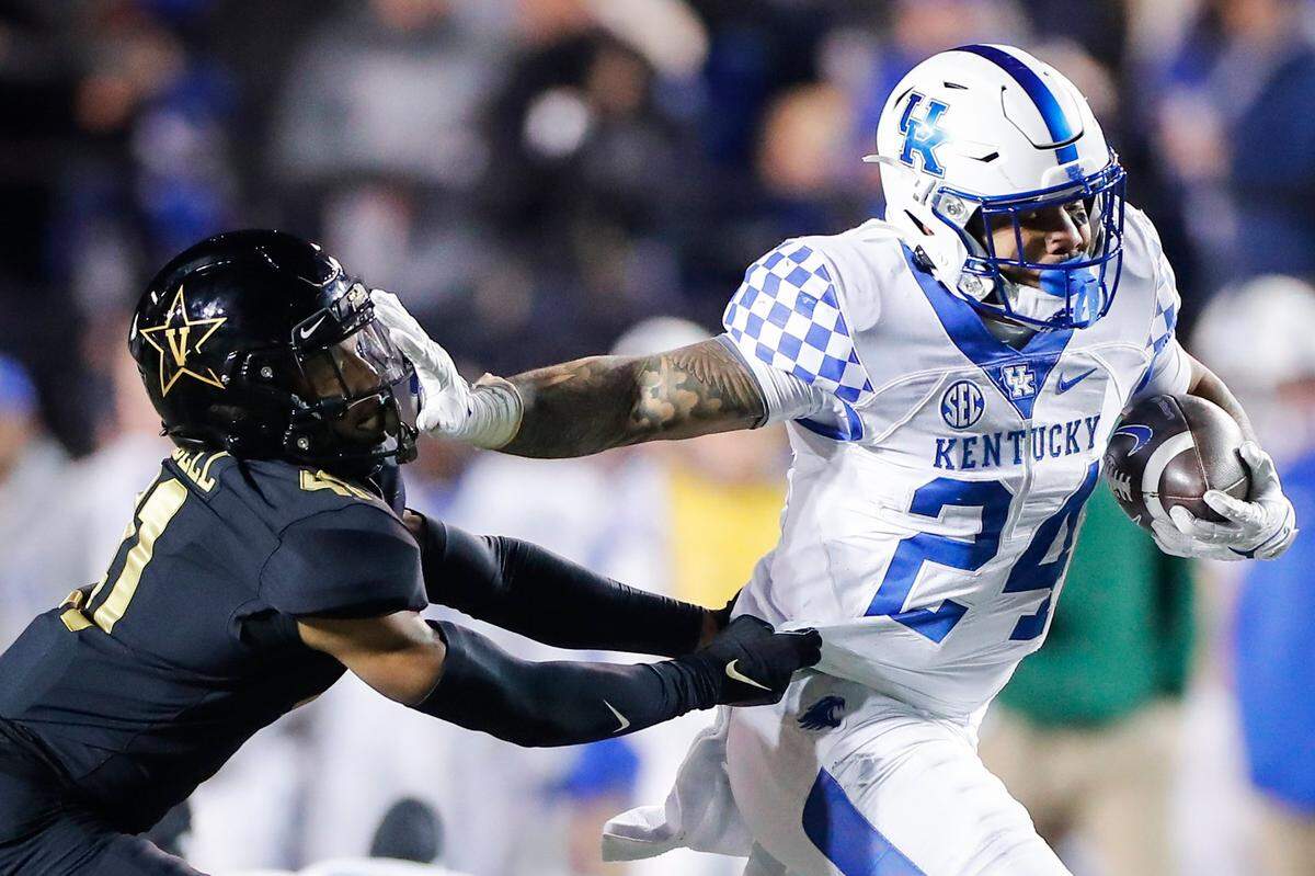 Kentucky running back Chris Rodriguez runs past Vanderbilt’s Justin Harris during their game in Nashville on Nov. 13, 2021.
