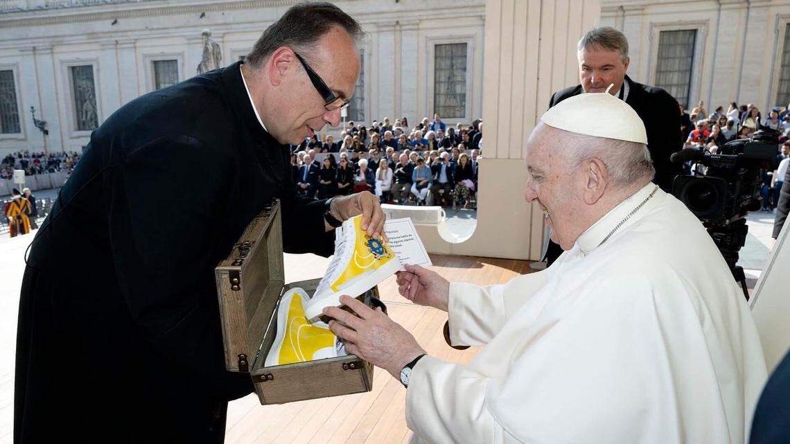 Father Jim Sichko gives a pair of customized shoes to Pope Francis. The shoes were designed by Lexington artist Billy Hobbs.