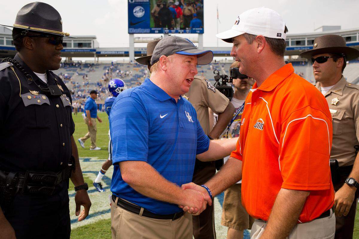 Kentucky Coach Mark Stoops, center, shook hands with Tennessee Martin head man Jason Simpson after the Wildcats defeated UTM 59-14 in the 2014 season opener.