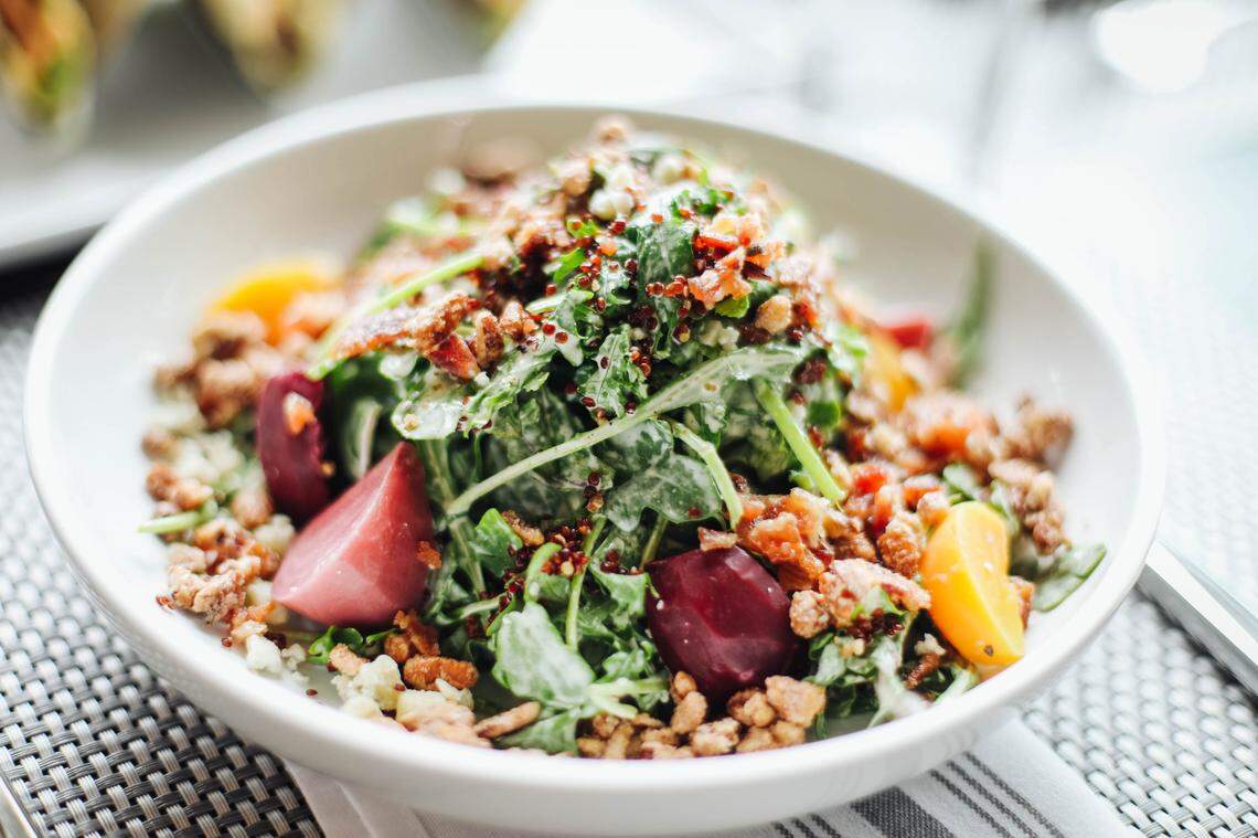 A baby kale quinoa and arugula salad with candied peppered bacon, pecans, blue cheese, beets and orange-ginger dressing at Bardstown Bourbon Company.