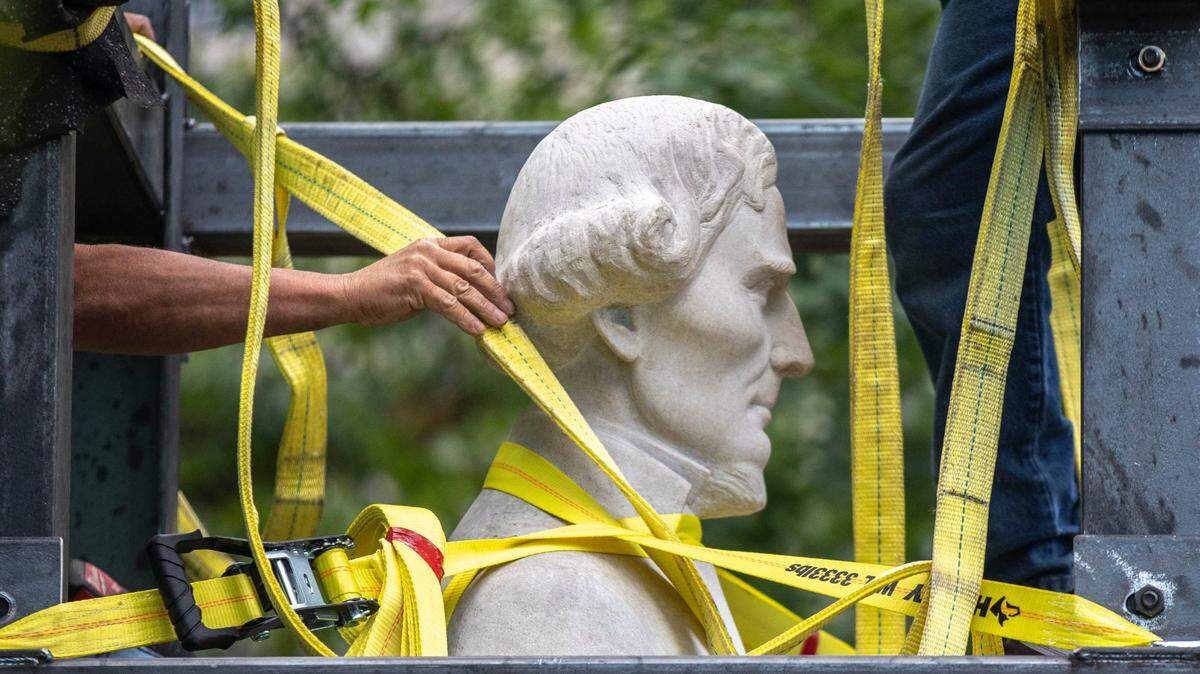 Workers secure the Jefferson Davis statue to a trailer after removing it from the Kentucky state Capitol in Frankfort, Ky., on Saturday, June 13, 2020.