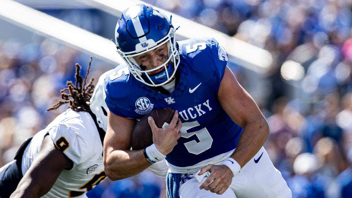 Kentucky quarterback Zach Calzada (5) tries to elude a Toledo defender during Saturday’s game at Kroger Field.
