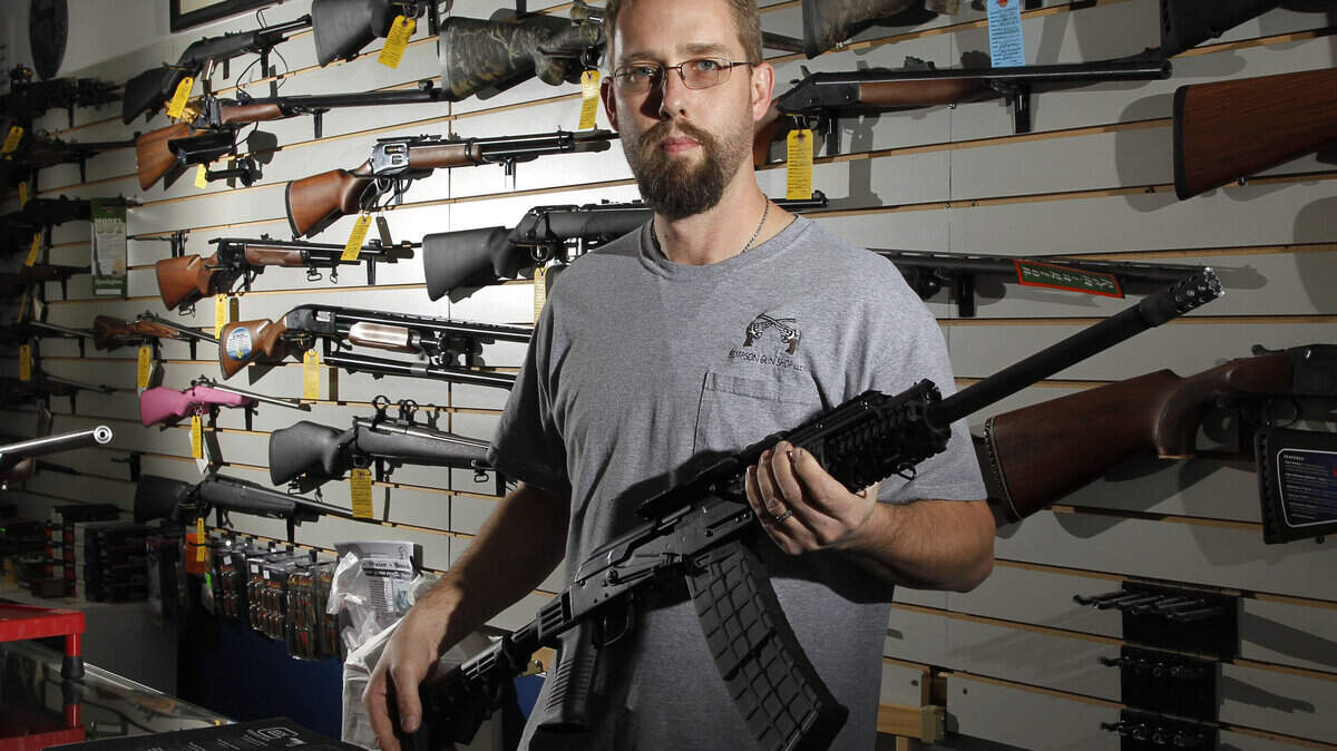 Vance Simpson held a Saiga-12 semiautomatic shotgun at his shop Friday. Simpson said demand for assault weapons is high.