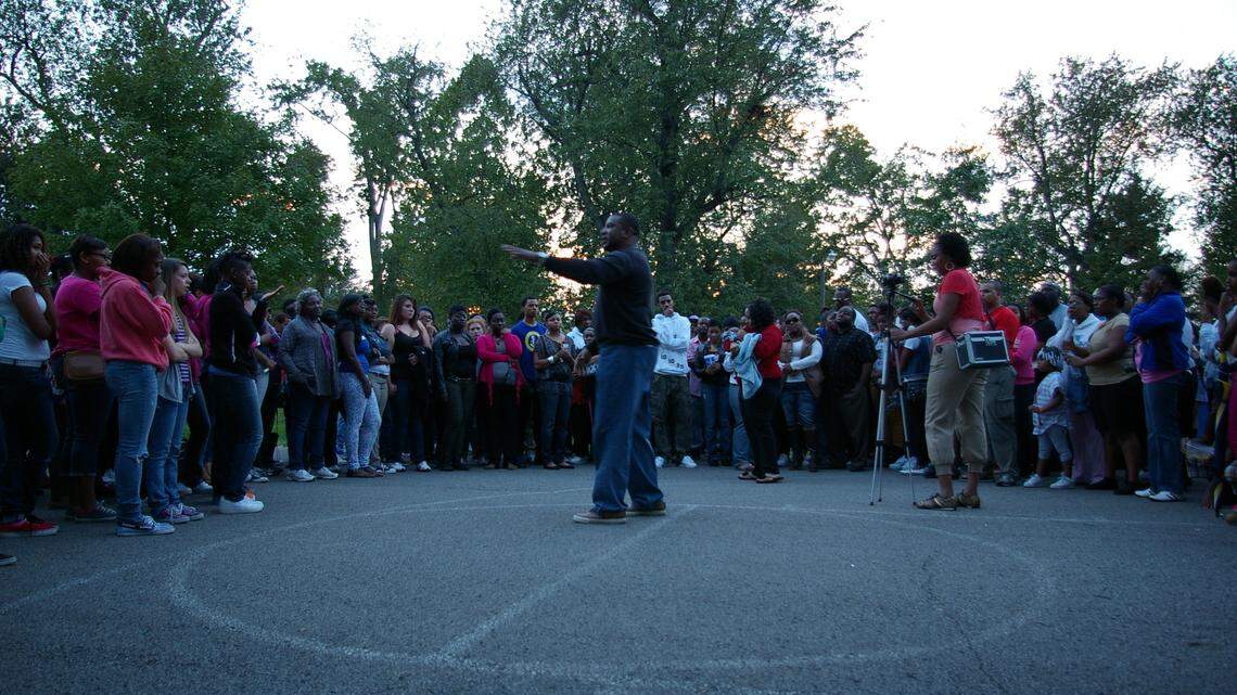 Jaleel Raglin's father, Charles Raglin, center, addressed more than 200 people who attended a candlelight vigil at Highland Park in Jaleel's memory on Thursday, two days after the 16-year-old was shot to death at a Winburn Drive apartment.    