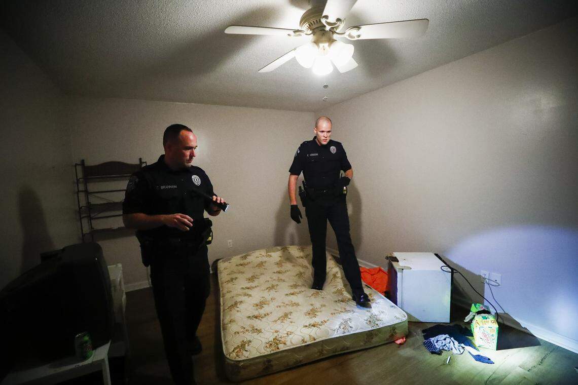 Pikeville Police Sgt. Chad Branham, of Pikeville, Ky., left, and Patrolman Colby Hobson, of Virgie, Ky., search a house on Lancelot Court while serving a warrant in Pikeville, Thursday, Aug. 8, 2019. Upon arrival to the house three people were arrested for methamphetamine related offenses.