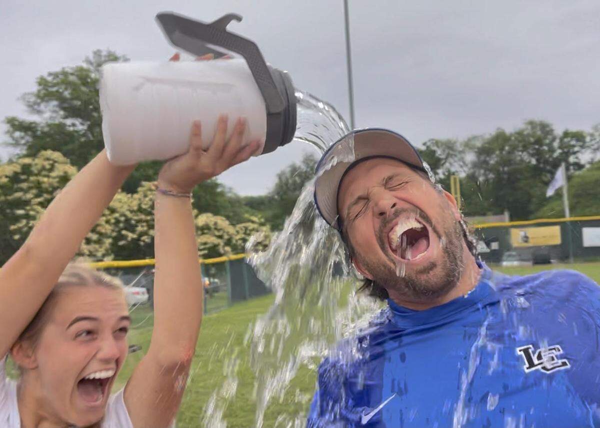 Lexington Catholic’s Ella Emmert delivers an ice-water bath to her dad and team coach Emery Emmert after the Knights’ 2-1 victory over host Lafayette in the 43rd District Tournament finals on Wednesday.