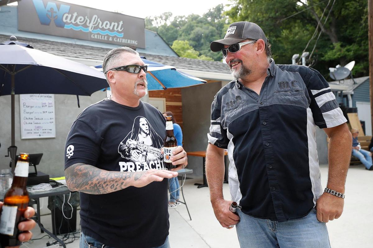 Kenny Adkins, left, and Ken Pack, both of Winchester, catch up before dinner in front of Waterfront Grille & Gathering in Winchester, Thursday, June 24. The Kentucky River dining spot had opened with a limited menu and hours but fully opened this week.
