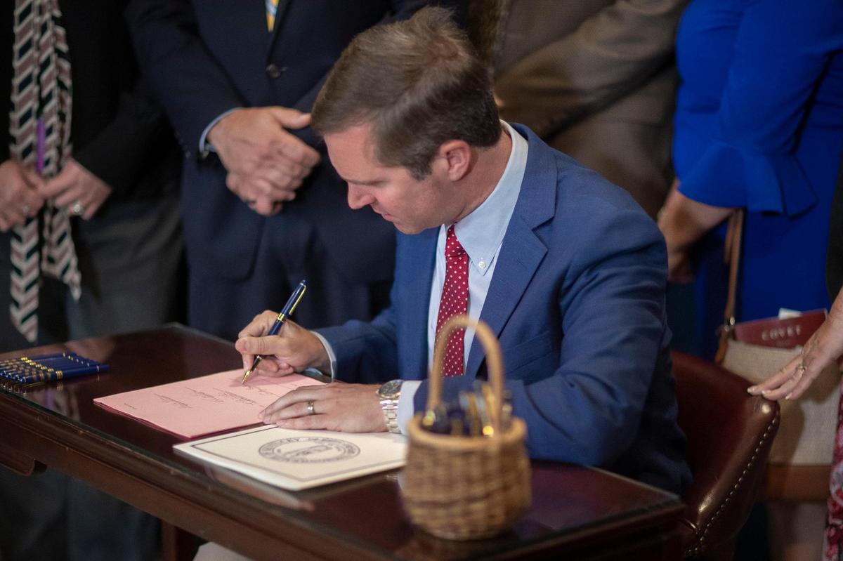 Kentucky Gov. Andy Beshear signs a $213 million aid package for flooded Eastern Kentucky at the Kentucky state Capitol on Friday, Aug. 26, 2022.