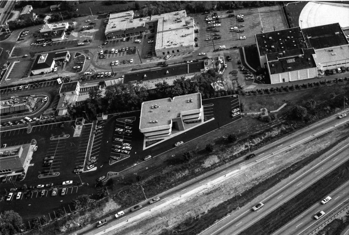 Off-ramp construction of New Circle Road leading to Richmond Road on Oct. 4, 1982. At the bottom left is Bob Evans restaurant and just above that is McDonald’s. Up in the far left corner is Sir Pizza and with the triangled striped roof, Kentucky Fried Chicken. In the right corner of the image is one of Lexington’s most elaborate fitness spas, the Sin The Sports Center. Sin The, a 10th-degree black belt and the world’s grand master of the Shao Lin school of karate, opened the gym in 1978 and at one time had more than 5,000 members. The complex featured Nautilus, karate, trimnastics aerobic dance, body shaping, olympic weight lifting, indoor pool and the popular salt-water wave pool, the large white area in the upper right corner of the image. The pool opened in 1981 and by next year The brought in sand by the pool and even had a couple tons of seashells so that people could go “shelling” on the beach. In November 1986 the spa was closed after reorganization under Chapter 11 and auctioned.