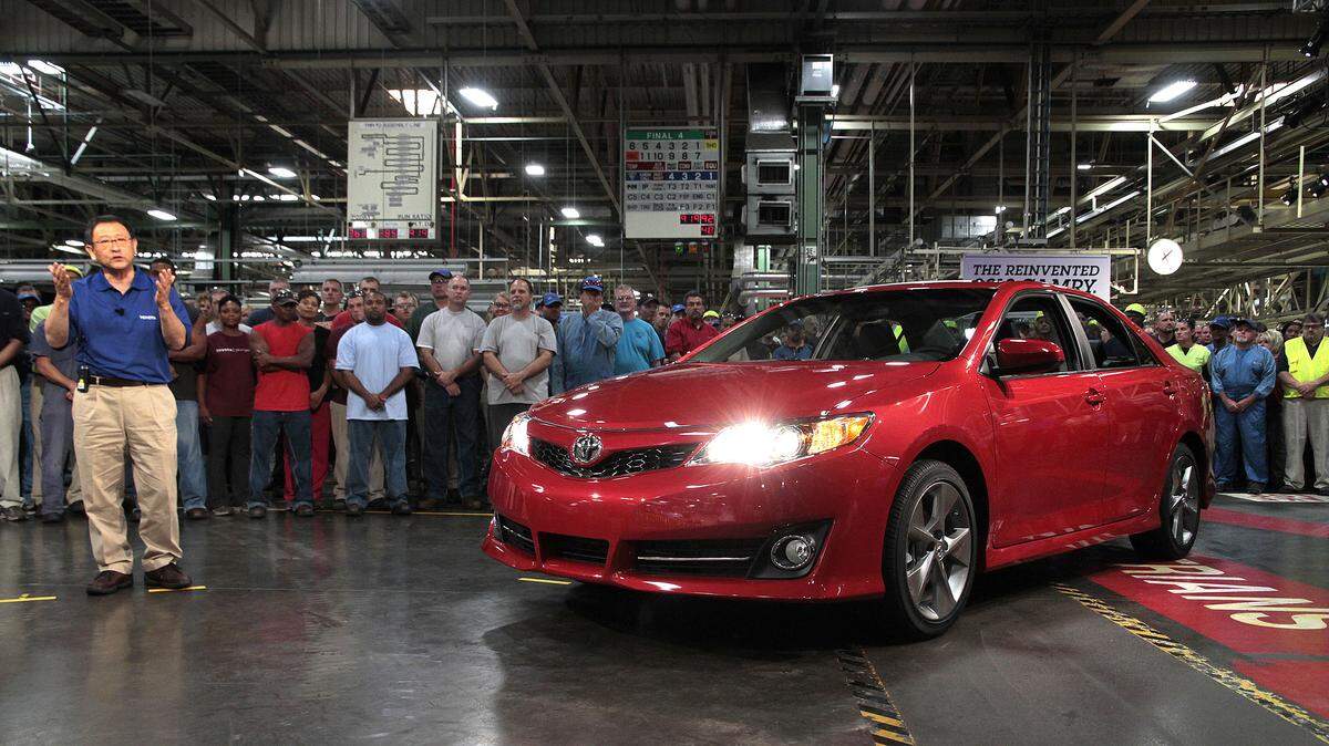 Aug. 23, 2011: Akio Toyoda, left, president and CEO of Toyota Motor Corp., spoke during a webcast at the unveiling of the 2012 Camry in Georgetown. Toyoda drove the car off the line to the applause of assembly line workers.