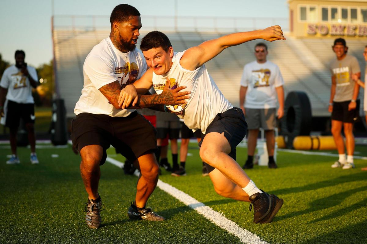 Lynn Bowden, left, ran a play with Somerset High School running back Guy Bailey during the Somerset Youth Football League camp at Williams Clark Football Field in Somerset on Saturday. Bailey also attended the camp to work with participants.