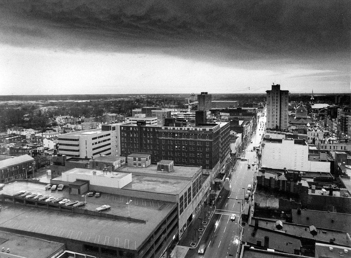 A line of heavy thundershowers passed over downtown Lexington the morning of Dec. 5, 1977. The storm dropped 1.52 inches of rain on the city. The Purcell Building was struck by lighting leaving debris on Main Street. The picture was taken looking west down Main Street from atop the First Security Building, today called Chase Tower. Directly in the middle of the image is the Phoenix Hotel. It was demolished in 1981 and 1982 by Wallace Wilkinson, who planned to use the site to build the World Coal Center skyscraper. It was never built, and the site eventually became the Park Plaza Apartments and Phoenix Park. Next to it towards the bottom of the image is what is now the Lexington Public Library, the Police Department, the Fayette County Clerks office and the Helix Garage. In the background, just above the Phoenix Hotel you can see construction taking place for the 22-floor high-rise Kincaid Towers.
