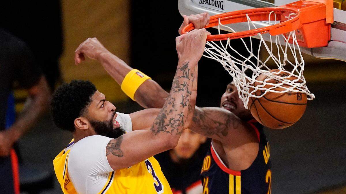 Lakers forward Anthony Davis, left, dunked as Warriors forward Kent Bazemore defended during the second half their Western Conference play-in game on Wednesday.