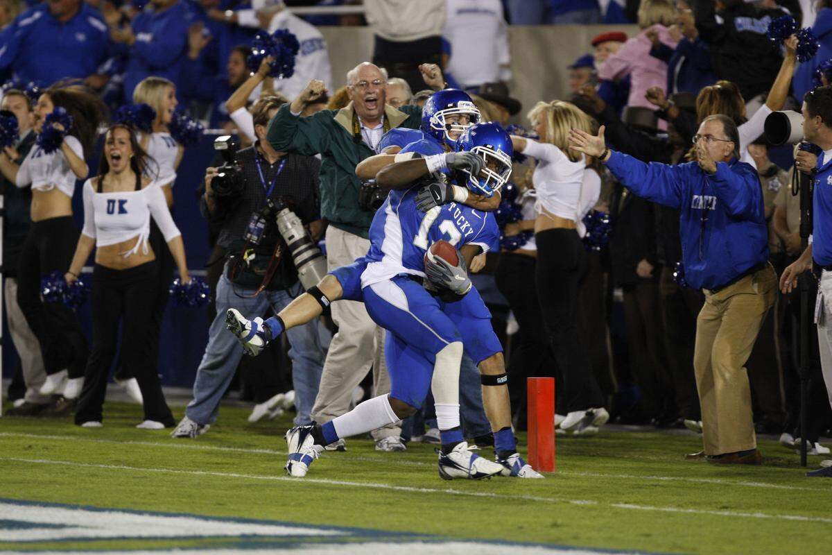 Kentucky's Steve Johnson (13) was grabbed by Dicky Lyons Jr. after Johnson scored the winning touchdown in Kentucky's 40-34 victory over No. 9 Louisville in 2007.