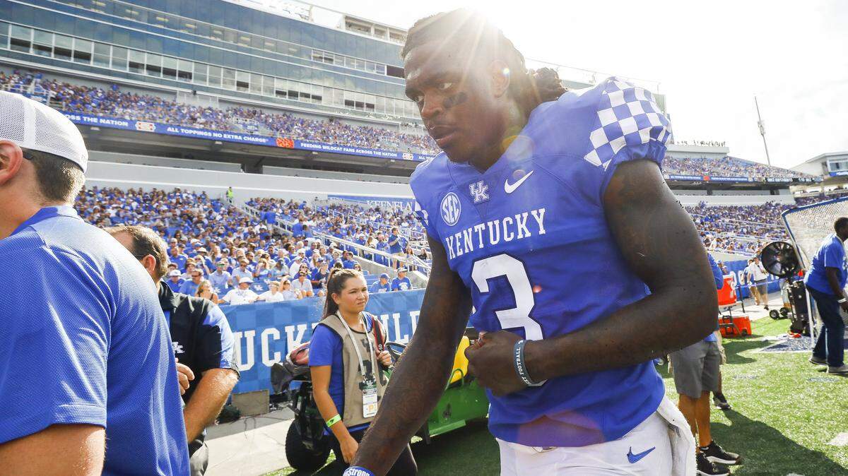 Kentucky quarterback Terry Wilson is taken off the field with an injury during a game against the Central Michigan Chippewas on Saturday at Kroger Field in Lexington.