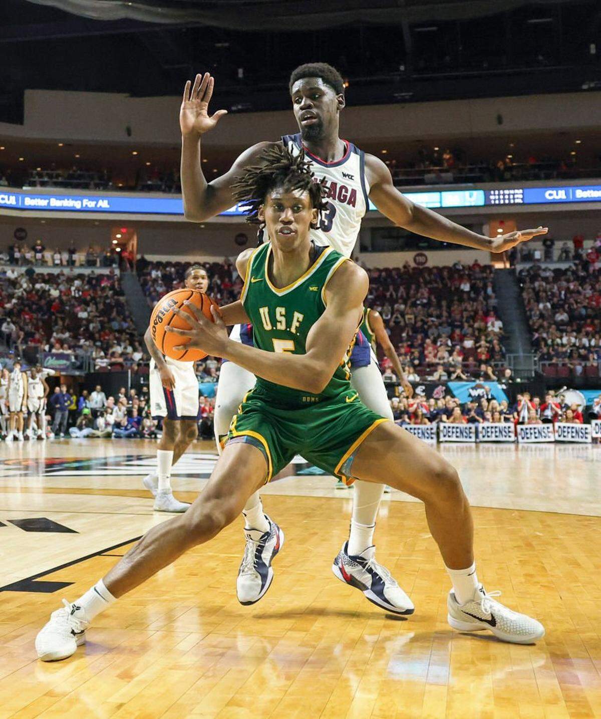 LAS VEGAS, NEVADA - MARCH 10: Tyrone Riley IV #5 of the San Francisco Dons is guarded by Graham Ike #13 of the Gonzaga Bulldogs in the second half of a semifinal game of the West Coast Conference men's basketball tournament at the Orleans Arena on March 10, 2025 in Las Vegas, Nevada. The Bulldogs defeated the Dons 85-76. (Photo by Ethan Miller/Getty Images)
