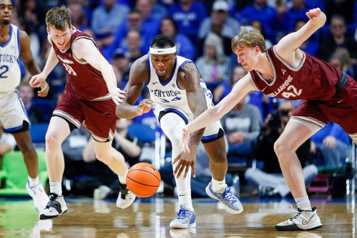 Kentucky’s Oscar Tshiebwe, center, tries to track down the ball between Bellarmine’s Garrett Tipton, left, and Curt Hopf on Tuesday at Rupp Arena. Tshiebwe finished with eight points, 12 rebounds, three blocks and two steals.