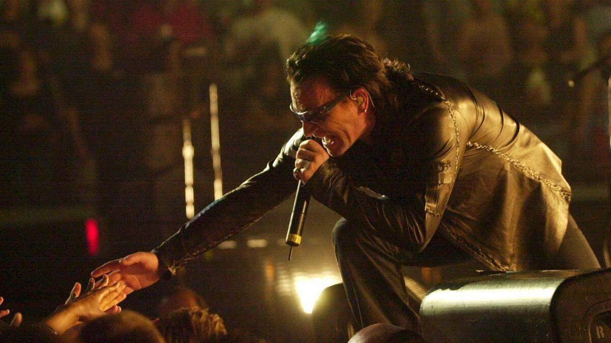 Bono, lead singer to the band U2, reached out and touched some hands at their performance at Rupp Arena in Lexington Ky., May, 4, 2001.