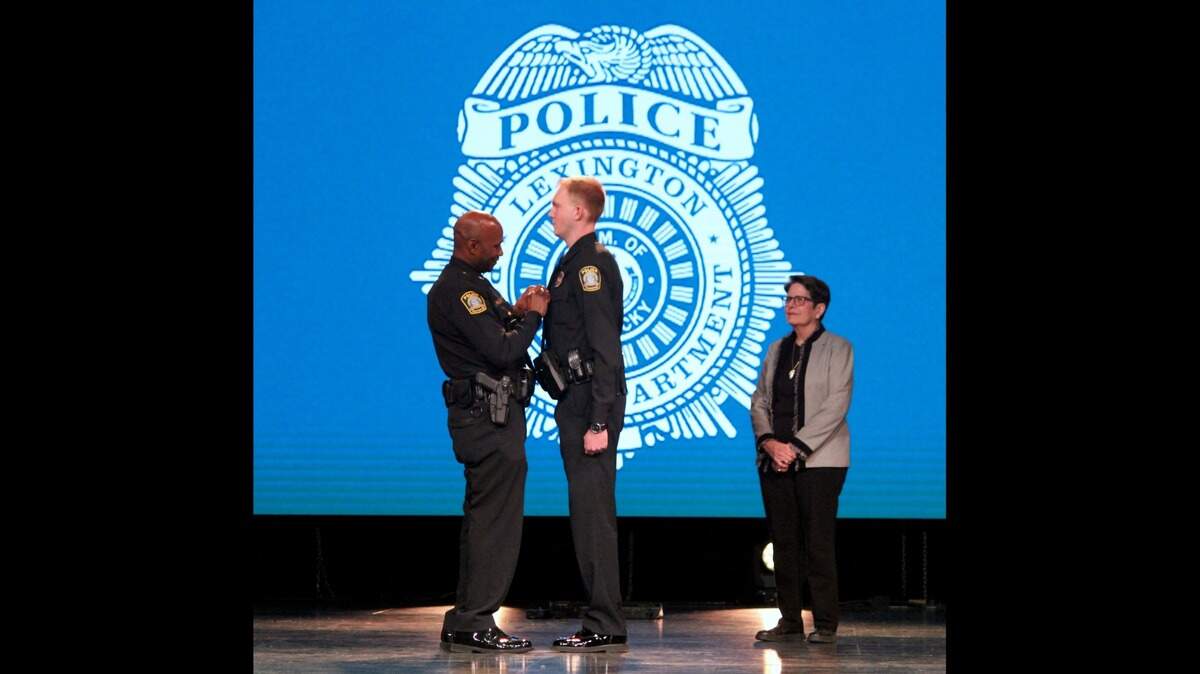 Lexington police chief Lawrence Weathers pins a badge on Matthew Jacobs, a Lexington native, during a Lexington police training academy graduation ceremony on Jan. 6, 2023.