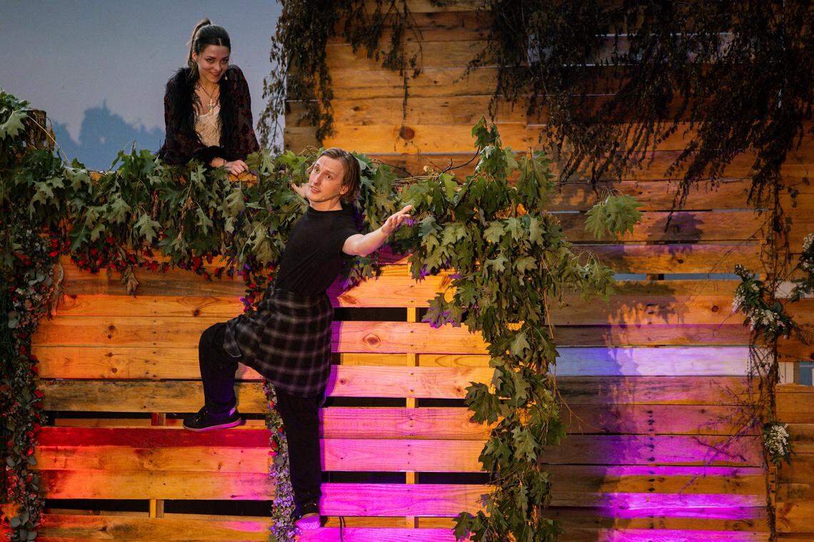 Steven Maddox, center, playing Romeo, climbs up a wall to speak with Daryn Russell, playing Juliet, on her balcony during a showing of Romeo and Juliet on Friday, July 18, 2025, at Woodland Park in Lexington, Ky.