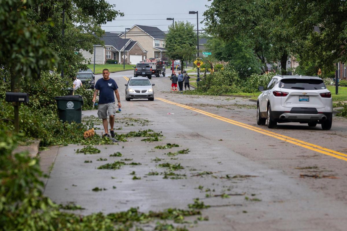Residents work to remove trees, branches and other debris along Sandersville Road in Lexington, Ky., on Thursday, June 26, 2025, following a storm with strong winds.