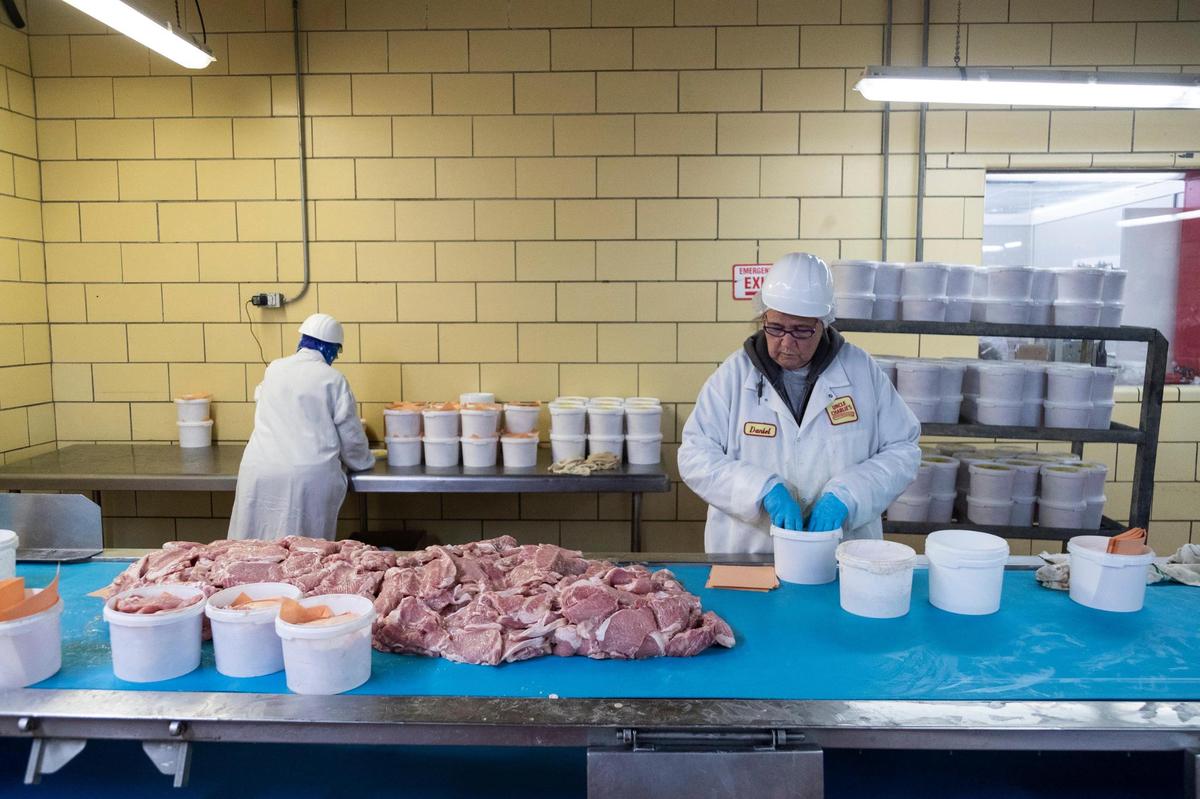 Workers prepare products for shipping and sale at Uncle Charlie’s Meats processing plant in Richmond, Ky., Friday, May 20, 2022. The mostly packaged retail operation has expanded recently into grocery stores throughout the state and region with popular products like pork tenderloin and bacon.