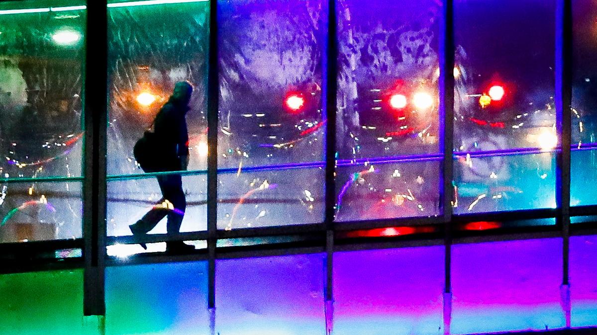 A man crosses the pedestrian walkway over Broadway between the Hyatt Regency and the Central Bank Building as it is illuminated with color changing LED lighting in Lexington, Ky., Wednesday, Jan. 22, 2020. Both pedestrian walkways over Broadway will be illuminated nightly as part of the LexLights! Initiative.