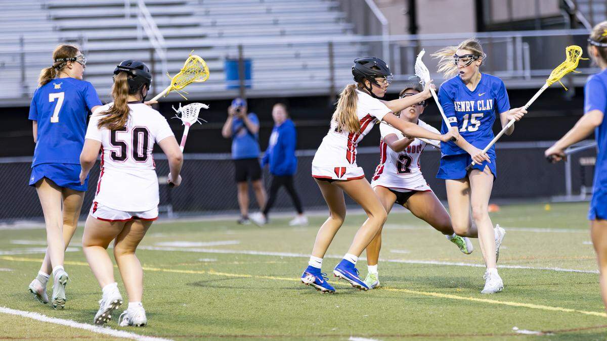 Henry Clay’s Audrey Webster (15) pushes forward against Paul Laurence Dunbar’s defense as twin sister Amelia Webster prepares to pivot to receive a pass during the Blue Devils’ 10-3 win at Paul Laurence Dunbar High School on Monday.