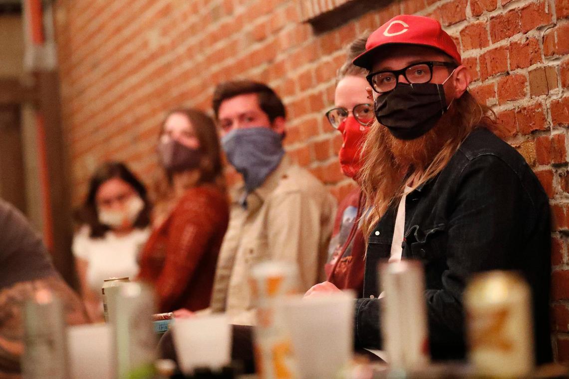 Chris Evans, right, of Lexington, Ky., and others watch as Robby Cosenza and Joshua Wright of the band Thirsty Boots perform on the patio at Al’s Bar in Lexington, Wednesday, Oct. 14, 2020.