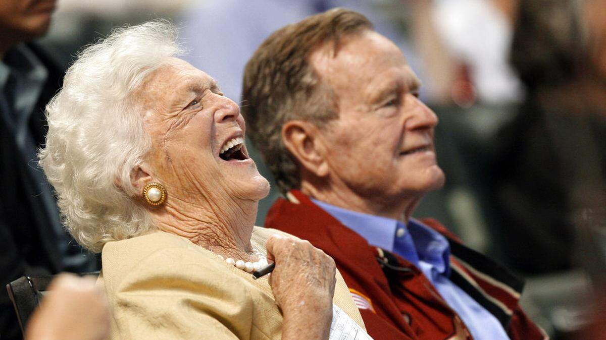 FILE - In this April 18, 2009, file photo, Barbara Bush laughs alongside former President George H.W. Bush, right, as they attend a baseball game in Houston. Barbara Bush, the snowy-haired first lady whose plainspoken manner and utter lack of pretense made her more popular at times than her husband, President George H.W. Bush, died Tuesday, April 17, 2018. She was 92. (AP Photo/David J. Phillip, File)