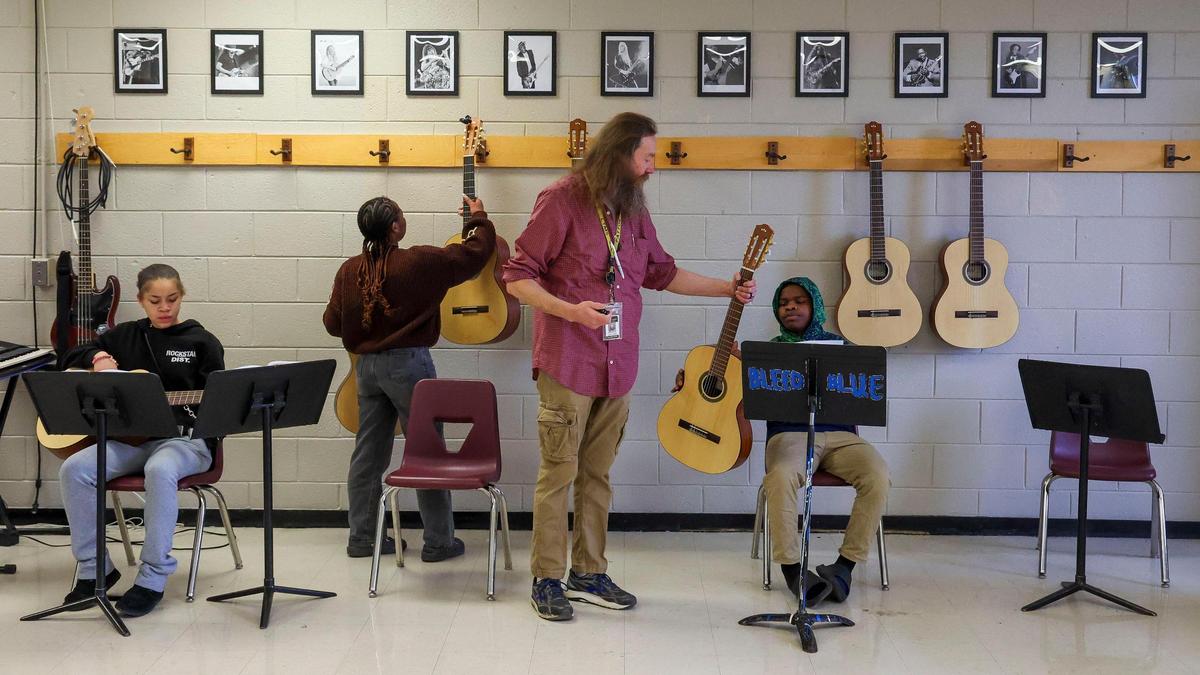 Teacher Lance Patton helps students tune guitars before class at Lexington Traditional Magnet School. He also teaches Latin.